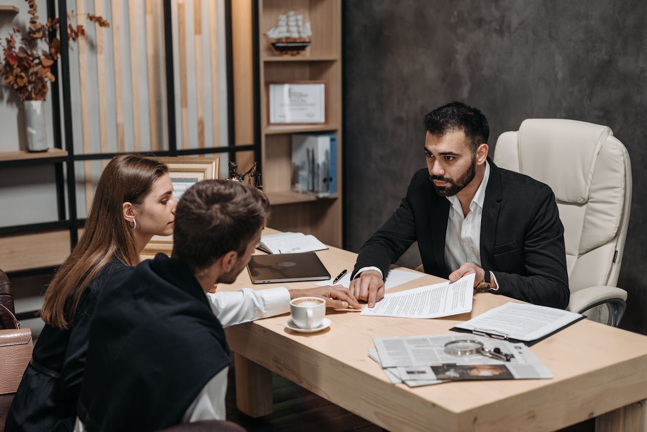 Mastering the First Impression: Your intriguing post title goes here Lawyer discussing legal documents with clients at office desk.